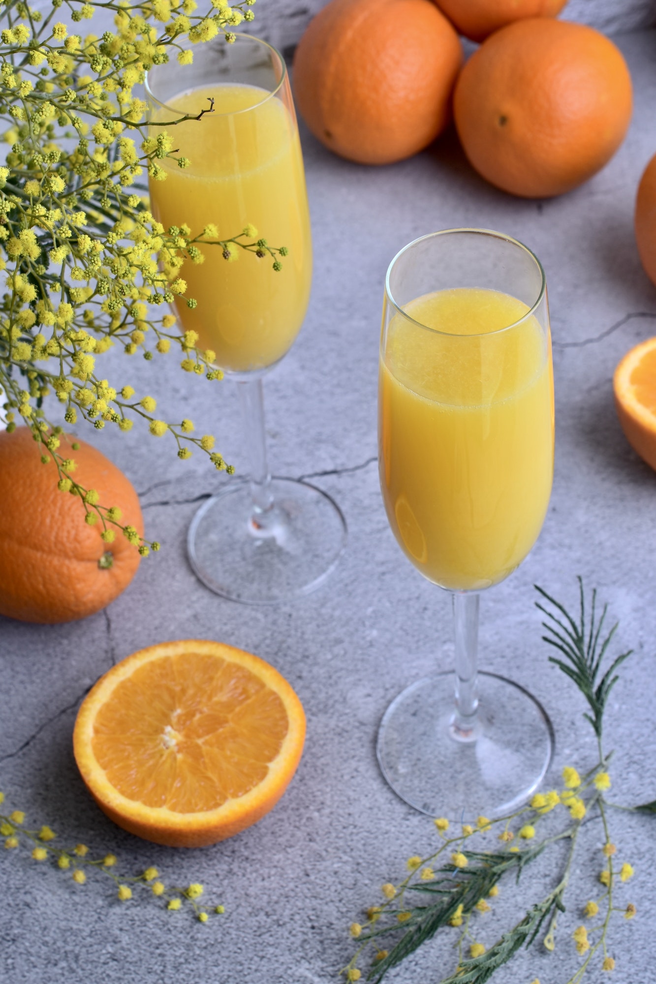 mimosa drinks and oranges on a counter